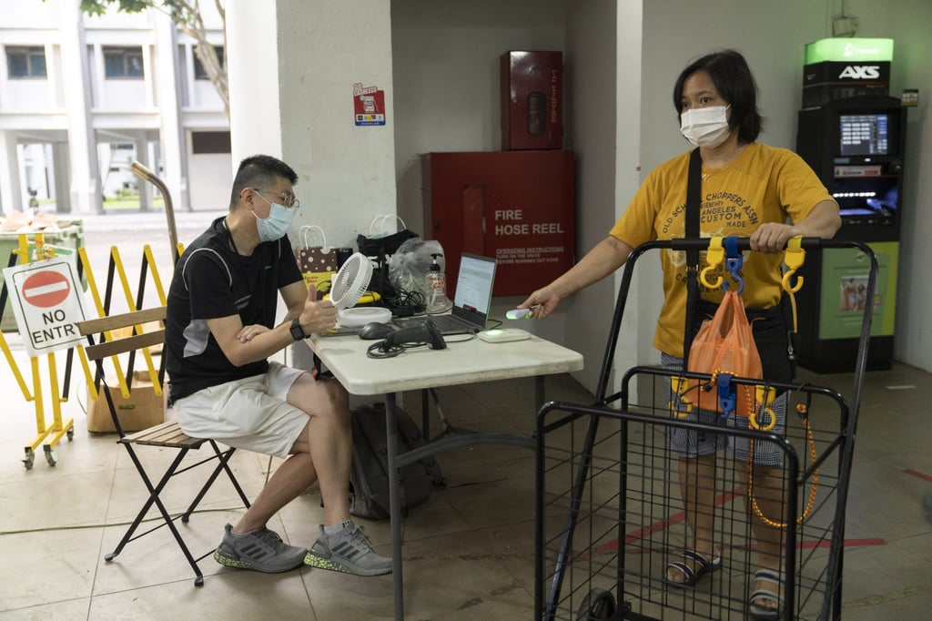 A visitor to a market in Singapore checks in using a ‘Trace Together’ contact-tracing token earlier this month. Photo: Bloomberg