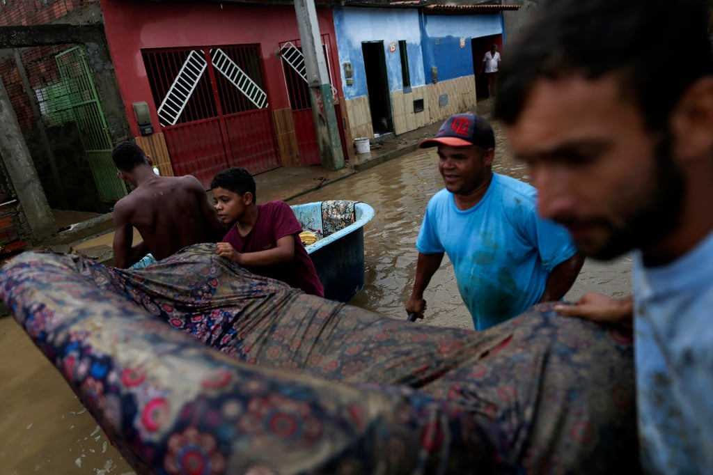 Residents clean out their flooded homes in Itapetinga, Bahia state, Brazil on December 28. Photo: AP