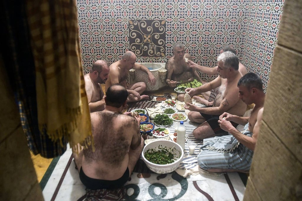 Men eat lunch after bathing at Hammam al-Qawas in Aleppo earlier this month. Photo: AFP