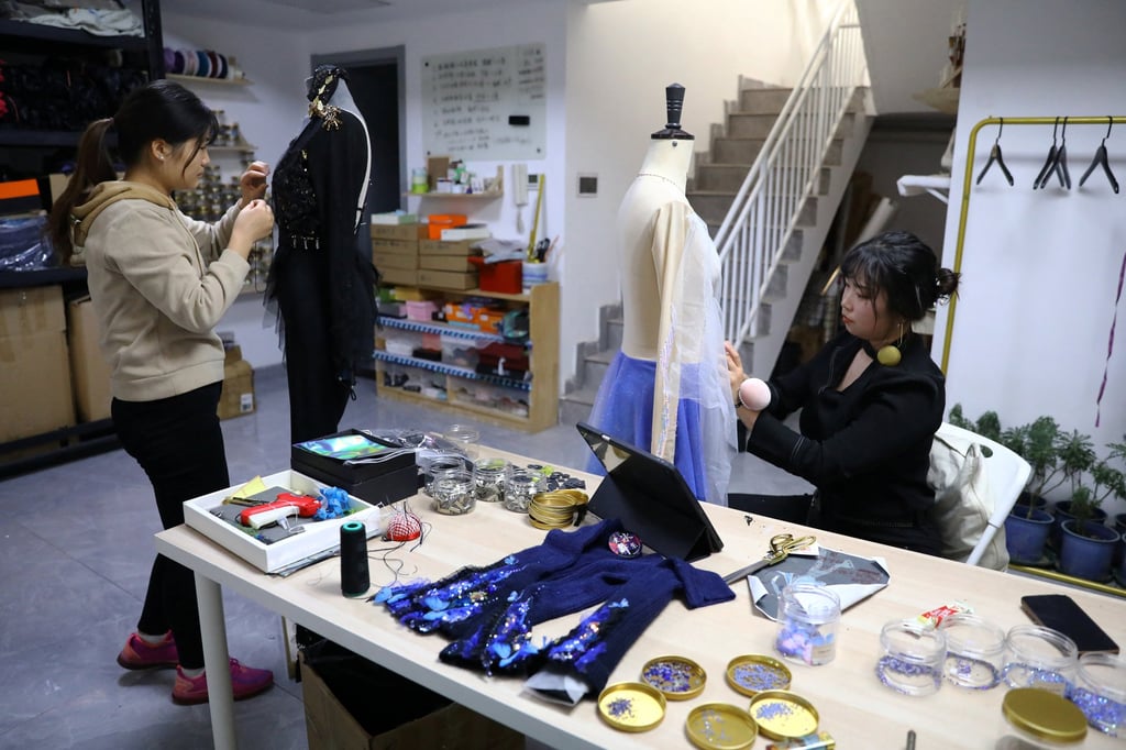 Zhang and a tailor work on skating outfits. Photo: Reuters/Tingshu Wang