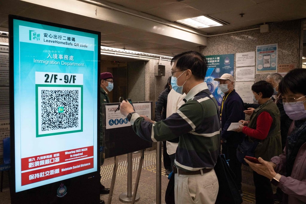 A man scans a QR code for the government’s ‘Leave Home Safe’ app to enter Immigration Tower on December 9, 2021. Photo: AFP