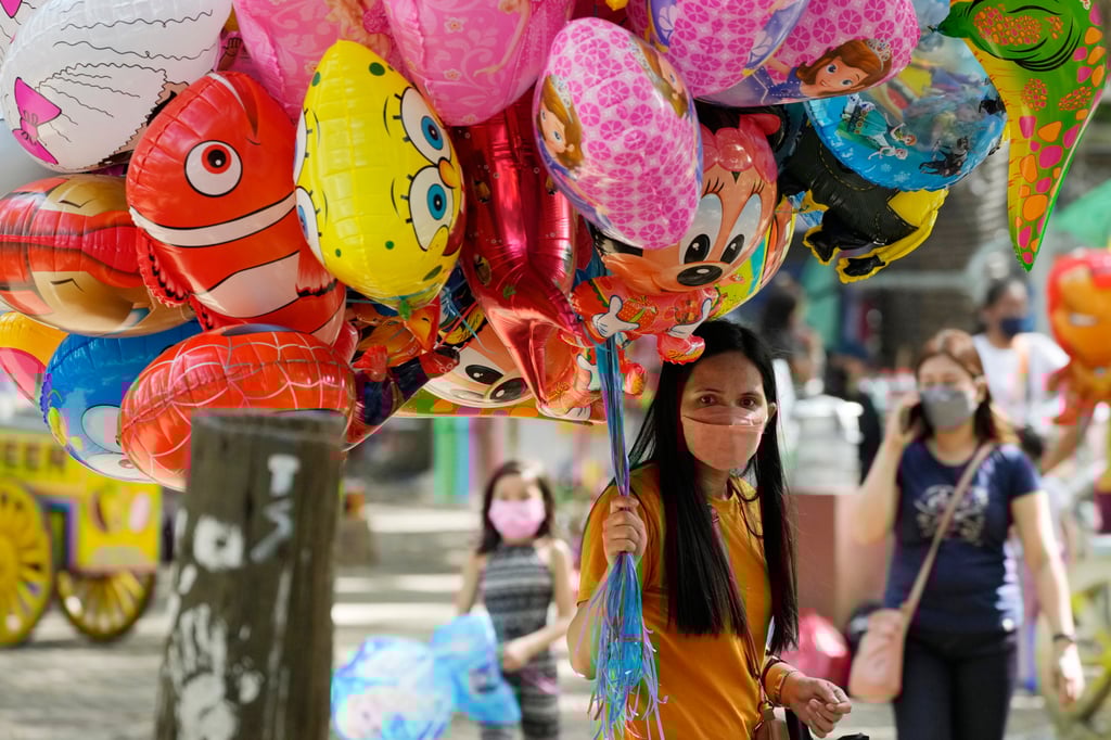 A party balloon-seller wearing a mask in Quezon City, Philippines. Photo: AP
