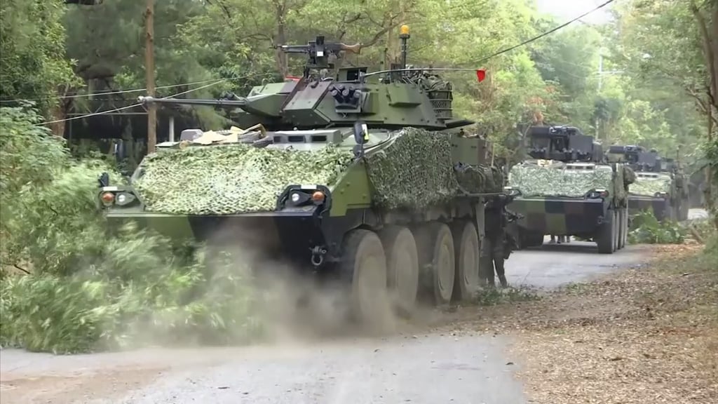 Armoured vehicles roll down a street during the simulated battle involving soldiers from two platoons. Photo: AP Armoured vehicles roll down a street during the simulated battle involving soldiers from two platoons. Photo: AP