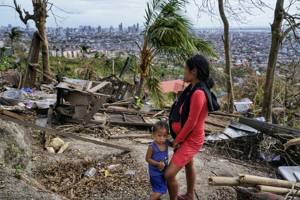 A woman stands with her son as she looks at their damaged house in Cebu city. Photo: AP A woman stands with her son as she looks at their damaged house in Cebu city. Photo: AP