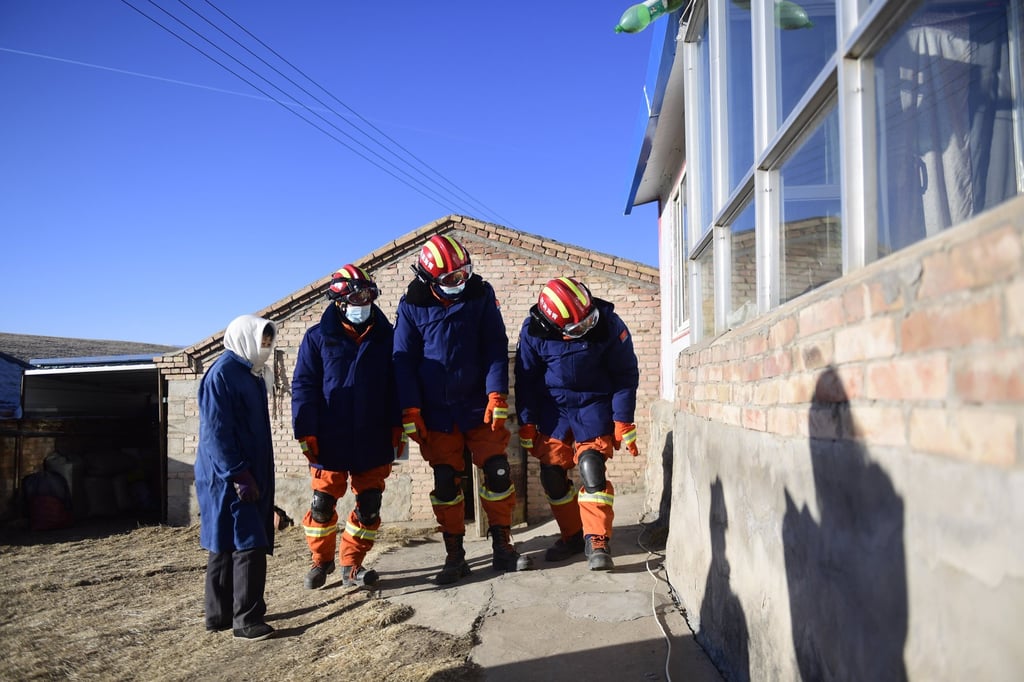 Firefighters check a building in a village in Menyuan Hui autonomous county. Photo: Xinhua via AP Firefighters check a building in a village in Menyuan Hui autonomous county. Photo: Xinhua via AP