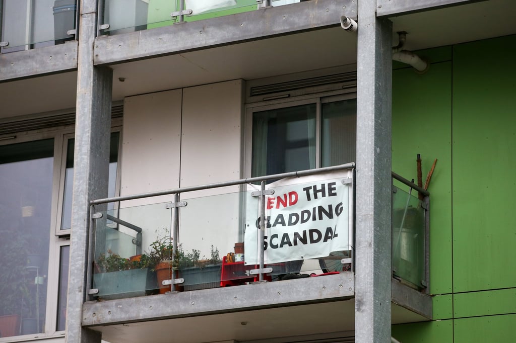 A banner that reads ‘End The Cladding Scandal’ hangs from a balcony of a flat at Co-operative House in Peckham, London. Photo: Bloomberg A banner that reads ‘End The Cladding Scandal’ hangs from a balcony of a flat at Co-operative House in Peckham, London. Photo: Bloomberg