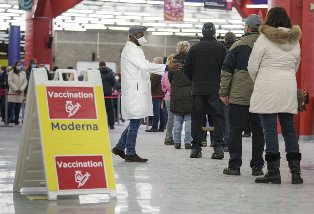 People line up to enter a Covid-19 vaccination clinic in Montreal on January 6. Photo: The Canadian Press via AP People line up to enter a Covid-19 vaccination clinic in Montreal on January 6. Photo: The Canadian Press via AP