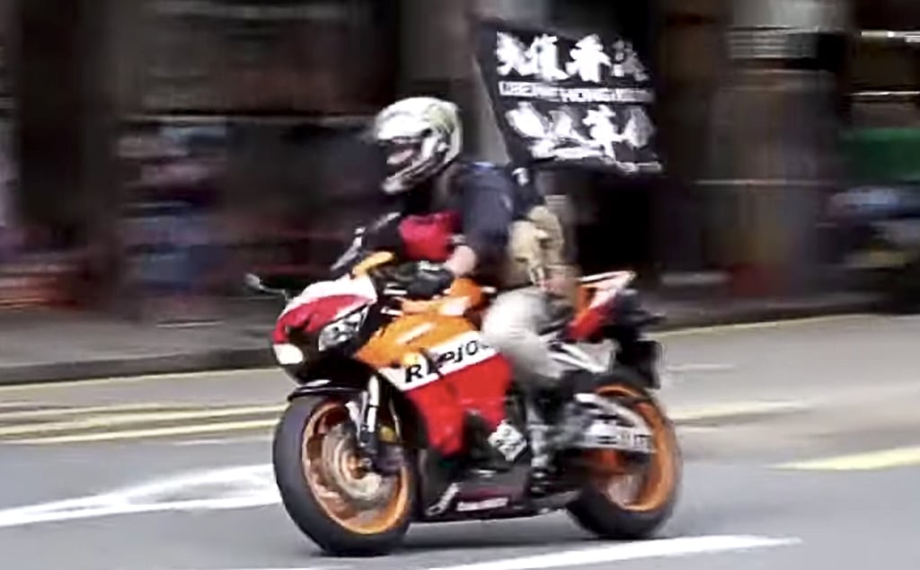Tong was found guilty of driving a motorcycle into three police officers and carrying a flag calling for Hong Kong’s “liberation”. Photo: Cable TV Tong was found guilty of driving a motorcycle into three police officers and carrying a flag calling for Hong Kong’s “liberation”. Photo: Cable TV