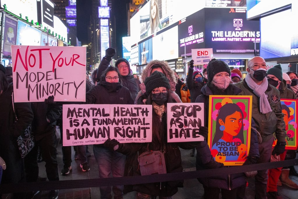 People taking part in a vigil for Michelle Alyssa Go in Times Square hold up signs while listening to speakers in New York on Tuesday. Photo: EPA-EFE