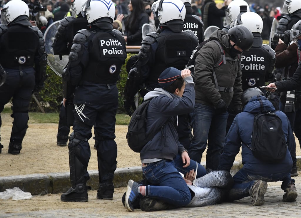 A man is detained during a demonstration against coronavirus measures in Brussels on January 23. Photo: AP