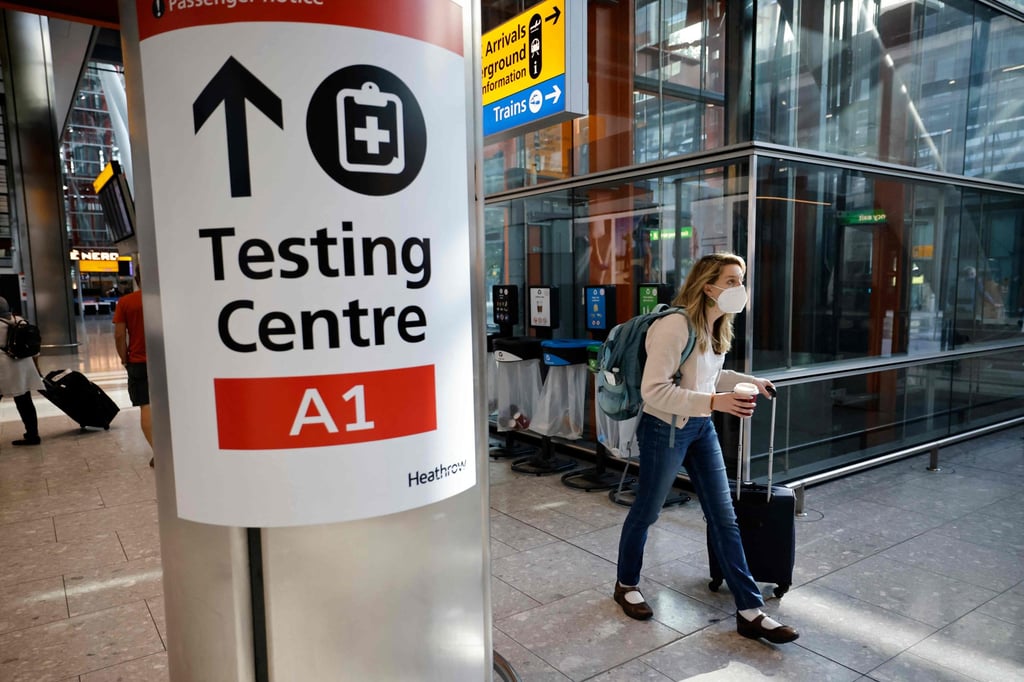 A traveller walks past a sign directing the public to a Covid-19 testing centre at London’s Heathrow Airport in August. Photo: AFP