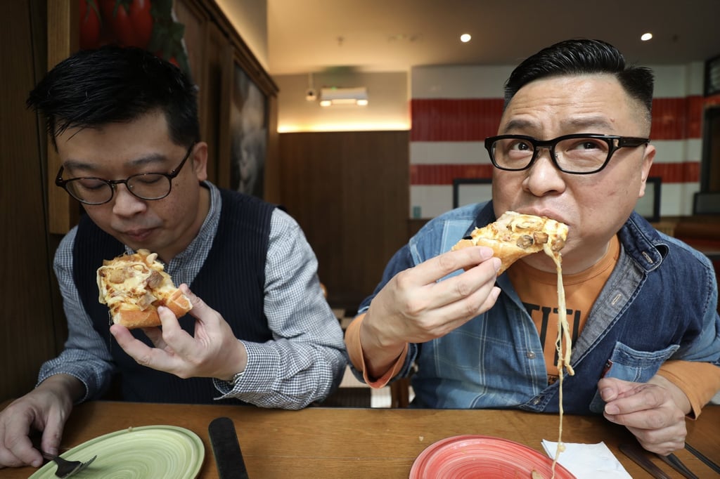 Blogger Gary Suen (left) and food writer Chan Chun-wai taste a Buddha Jumps Over the Wall pizza at Pizza Hut in Kennedy Town. Photo: Xiaomei Chen
