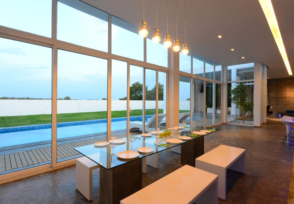 The dining area has large glass windows that allow guests to look out to the pool. Photo: houzz.in The dining area has large glass windows that allow guests to look out to the pool. Photo: houzz.in