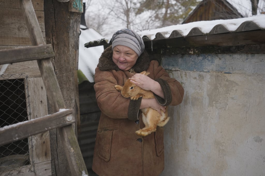 Olga, one of 16 residents still living in her frontline village, holds a rabbit in her yard not far from the front line in the Luhansk region, eastern Ukraine, on Friday. Photo: AP