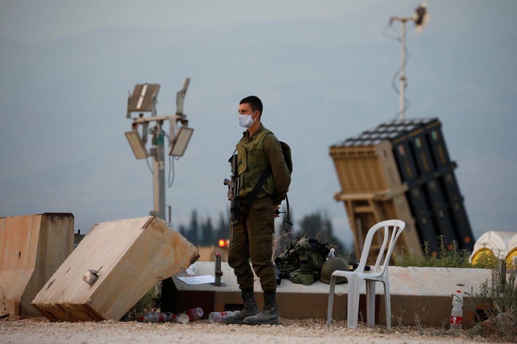 An Israeli soldier stands guard next to an Iron Dome anti-missile system near the country’s northern border with Lebanon in July 2020. Photo: Reuters