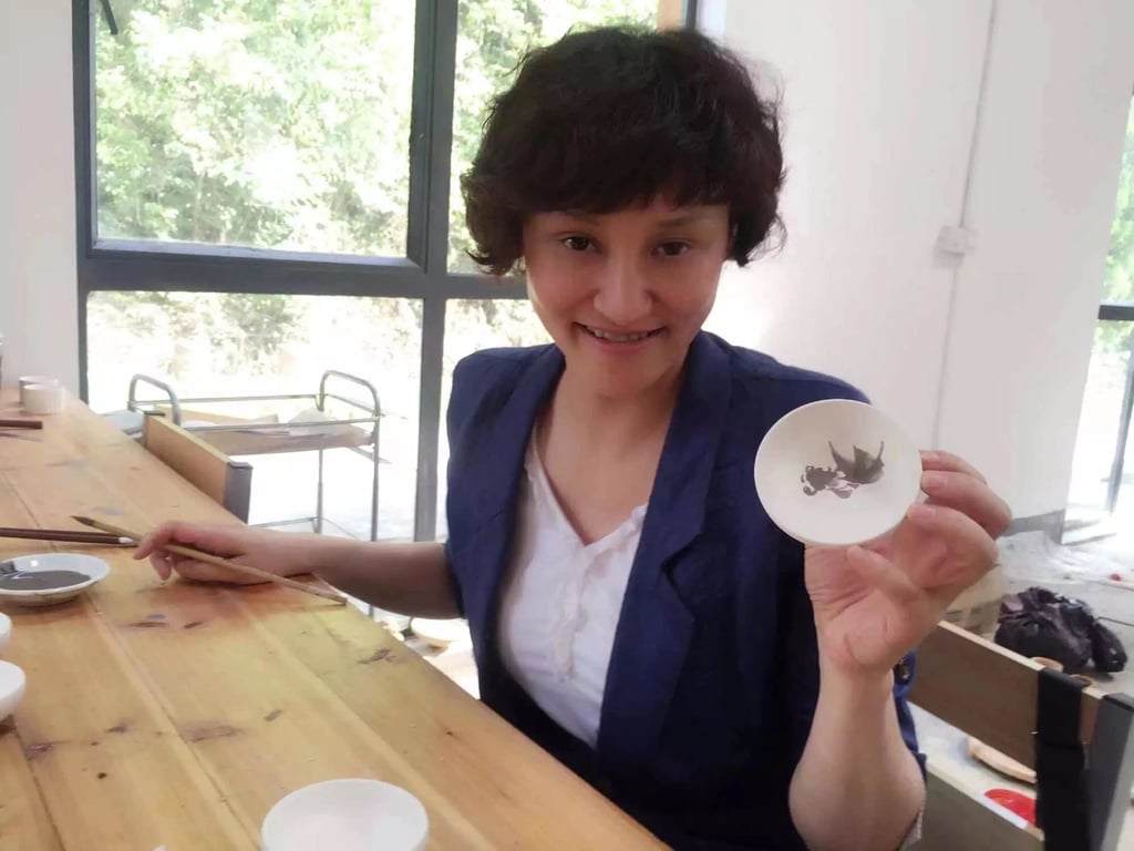 China’s former Olympic diver Gao Min shows off her artwork. Photo: IOC