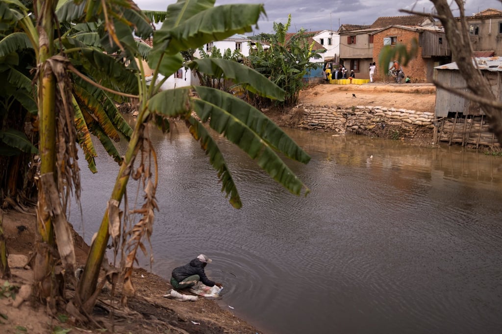 A man washes a bag in a river in the neighbourhood of Ambodimita, a day before Cyclone Batsirai is expected to hit Madagascar. Photo: Reuters