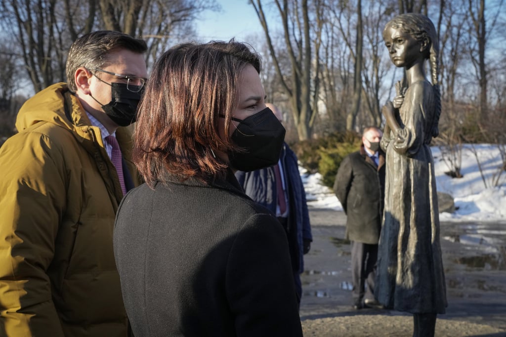 German Foreign Minister Annalena Baerbock, foreground, and Ukrainian Foreign Minister Dmytro Kuleba pay homage to famine victims during her visit to Kyiv on Monday. Ukraine has played down warnings that Moscow has stepped up preparations for a major incursion. Photo: AP