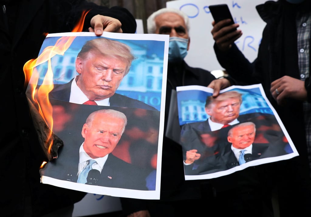 Protesters burn pictures of then US President-elect Joe Biden and then US President Donald Trump during a demonstration against the killing of Mohsen Fakhrizadeh, Iran’s top nuclear scientist, in Iran in 2020. Photo: via Reuters. Protesters burn pictures of then US President-elect Joe Biden and then US President Donald Trump during a demonstration against the killing of Mohsen Fakhrizadeh, Iran’s top nuclear scientist, in Iran in 2020. Photo: via Reuters.