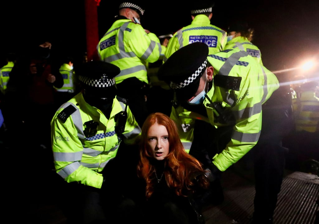 Police detain a woman as people gather at a memorial site in London in March 2021 following the kidnap and murder of Sarah Everard. Photo: Reuters Police detain a woman as people gather at a memorial site in London in March 2021 following the kidnap and murder of Sarah Everard. Photo: Reuters