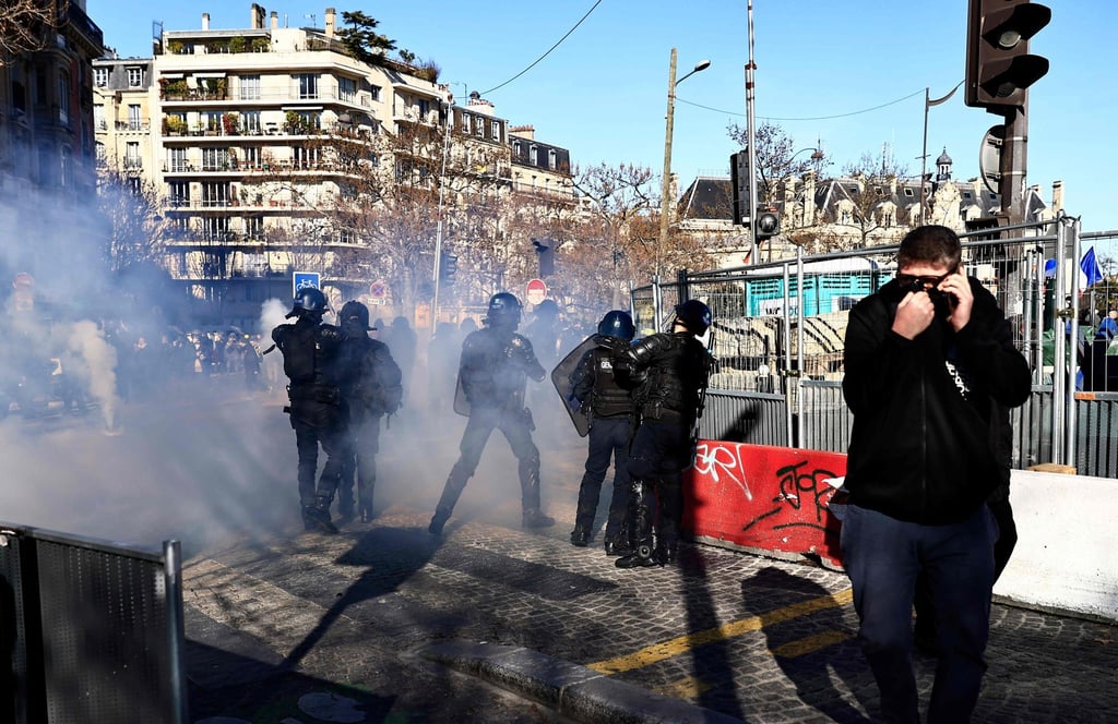 A demonstrator stands amidst tear gas at the Place d’Italie in Paris. Photo: AFP A demonstrator stands amidst tear gas at the Place d’Italie in Paris. Photo: AFP