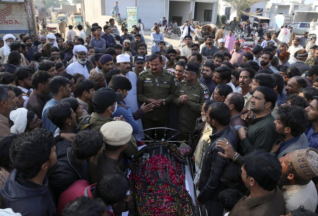 Police officers, relatives and villagers at the funeral of victim Mushtaq Ahmed, 41, in Tulamba on Sunday. Photo: AP