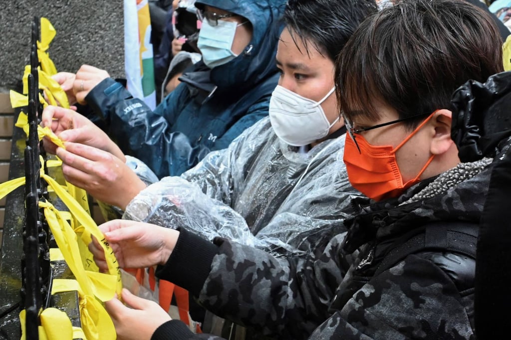 Protesters tie yellow ribbons onto the gates outside the Executive Yuan in Taipei. Photo: AFP Protesters tie yellow ribbons onto the gates outside the Executive Yuan in Taipei. Photo: AFP