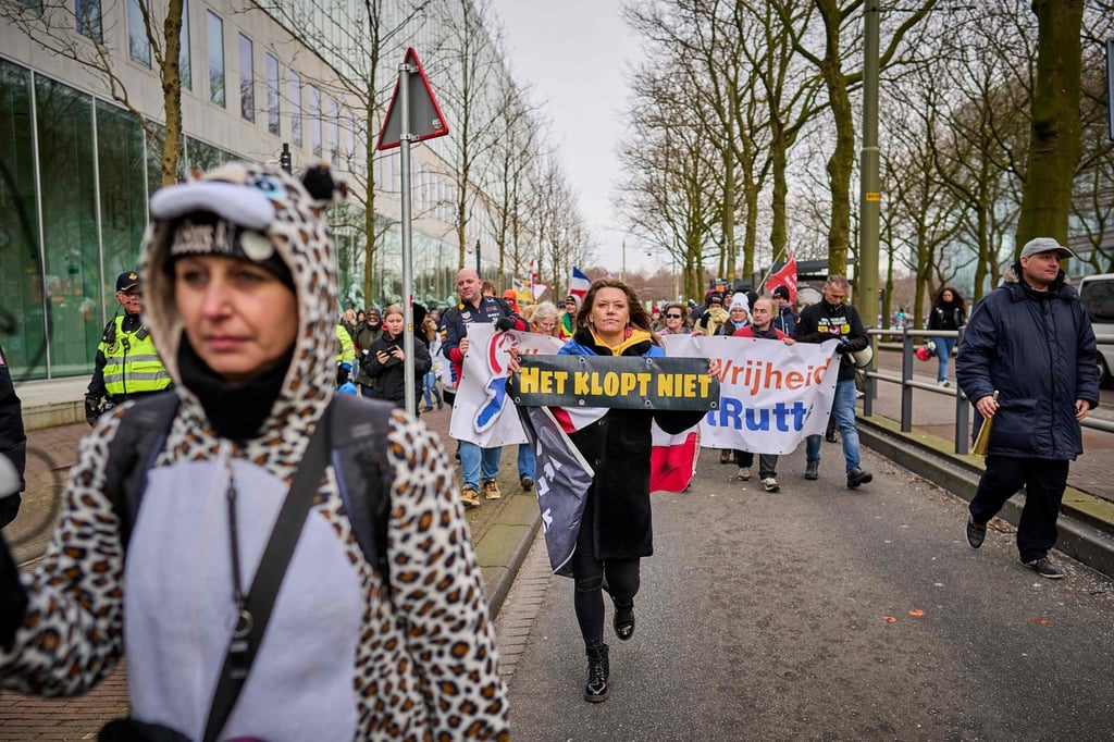 Demonstrators hold banners as they march in The Hague on Sunday to protest against the Dutch government’s coronavirus policies. Photo: AFP