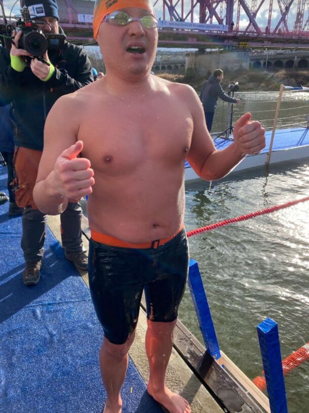 Chun Kong-mak has been ice swimming for four years, and his motivations have shifted over time from achievements to health and process. He attempts a thumbs up after a 1km race.