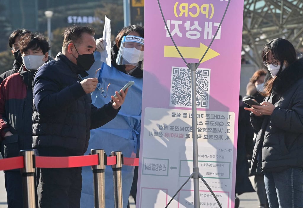 A health worker wearing protective gear directs people at a Covid-19 testing centre in Seoul on Friday. Photo: AFP A health worker wearing protective gear directs people at a Covid-19 testing centre in Seoul on Friday. Photo: AFP