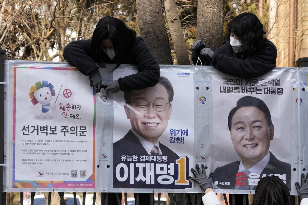 Workers put up posters of the liberal Lee Jae-myung (left) from the ruling Democratic Party, and conservative Yoon Suk Yeol of the main opposition People Power Party. Photo: AP Workers put up posters of the liberal Lee Jae-myung (left) from the ruling Democratic Party, and conservative Yoon Suk Yeol of the main opposition People Power Party. Photo: AP