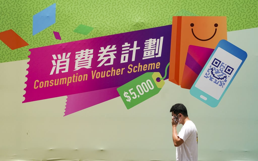 A man walks past a hoarding advertising last year’s consumption voucher scheme, which the government aims to replicate this financial year. Photo: Felix Wong