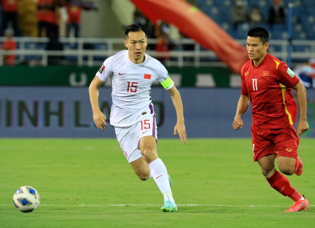 Wu Xi (left) chases after Vietnam’s Pham Tuan Hai during their World Cup Qatar 2022 Qualifier in Hanoi. China lost 3-1. Photo: Xinhua
