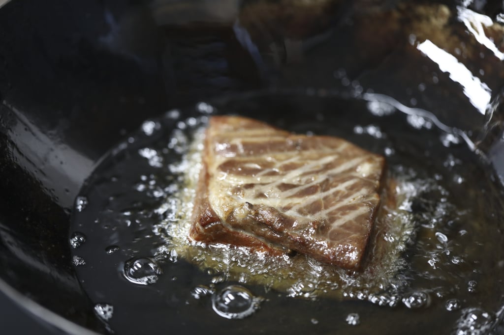 The pork belly is first simmered in a flavourful liquid, then air-dried in the fridge and deep-fried to crisp up the skin. Photo: Jonathan Wong