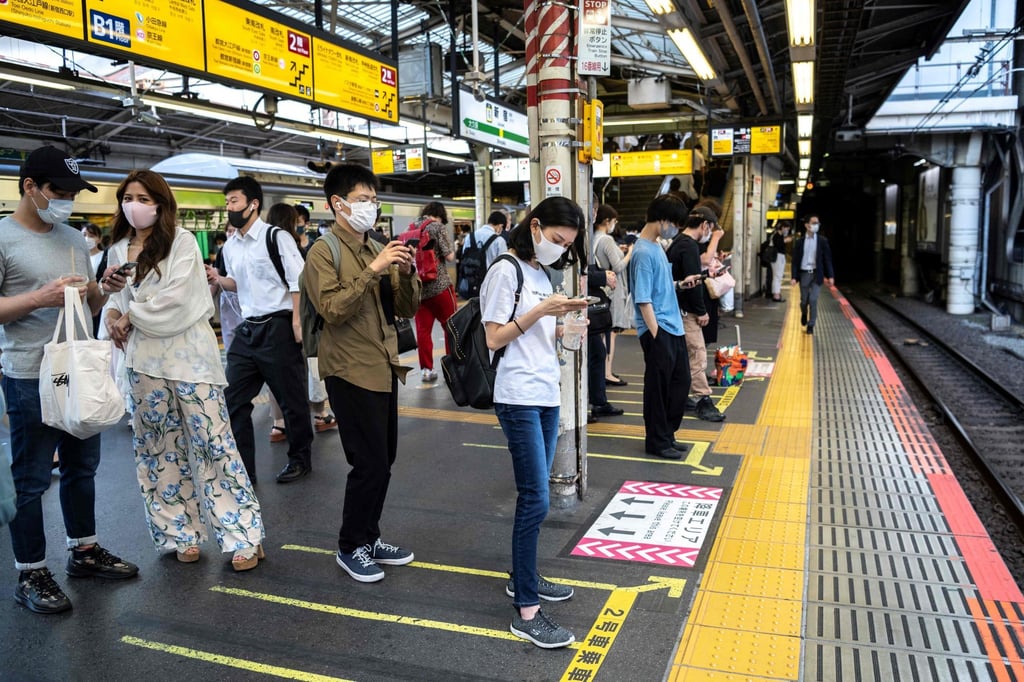 Commuters wait for a train in Tokyo. With social lives upended by the pandemic, office workers in Japan started turning to their colleagues for love. Photo: AFP