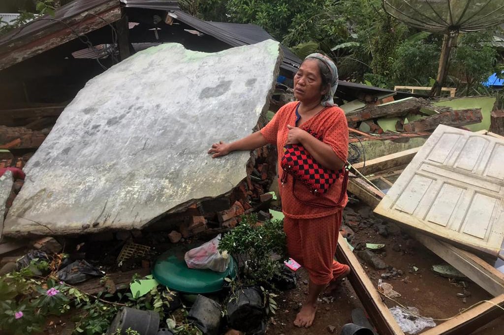 A woman stands in the ruins of her house after an earthquake in West Pasaman district, West Sumatra. Photo: AP