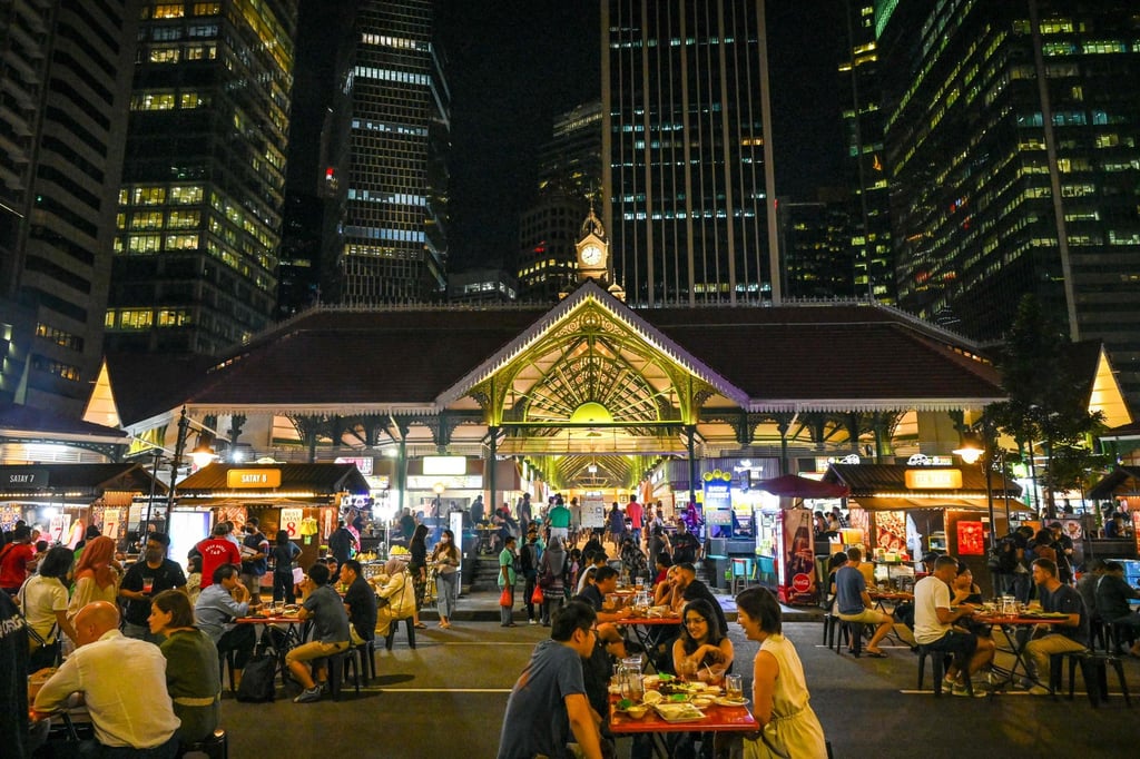 People in Singapore have their meals in an open-air area at the Lau Pa Sat hawker centre on February 18. In Singapore and many other places, there’s an acceptance the virus will be endemic. Photo: AFP People in Singapore have their meals in an open-air area at the Lau Pa Sat hawker centre on February 18. In Singapore and many other places, there’s an acceptance the virus will be endemic. Photo: AFP
