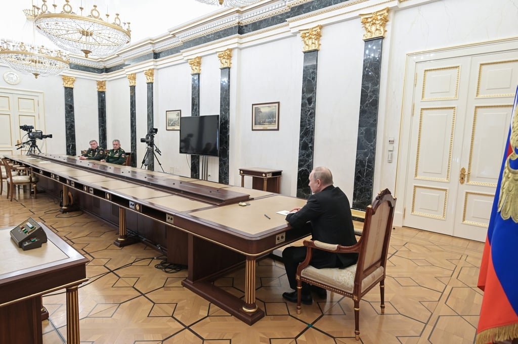 Russian President Vladimir Putin on Sunday sat stern-faced at a long table with his defence officials off to the side. Photo: AP Russian President Vladimir Putin on Sunday sat stern-faced at a long table with his defence officials off to the side. Photo: AP