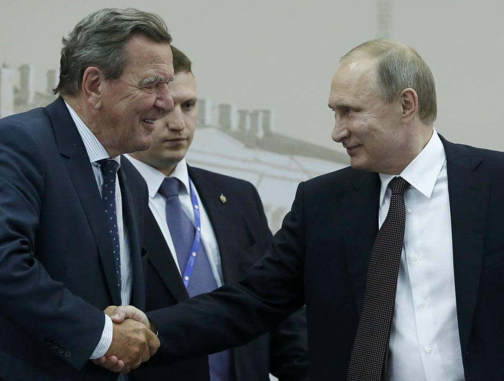 Russian President Vladimir Putin shakes hands with former German chancellor Gerhard Schroeder during the St Petersburg International Economic Forum 2016 in St. Petersburg, Russia. Photo: Reuters
