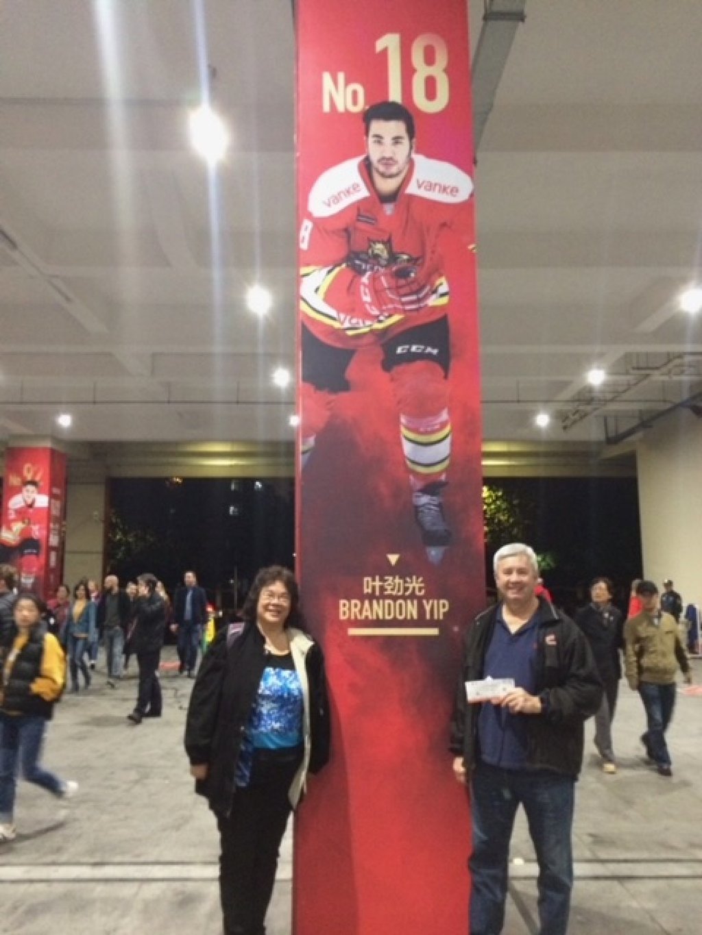 Gale (left) and Wayne Yip next to a poster of their son, Chinese ice hockey team and Kunlun Red Stars captain Brandon at a game in Shanghai in 2018. Photo: Handout Gale (left) and Wayne Yip next to a poster of their son, Chinese ice hockey team and Kunlun Red Stars captain Brandon at a game in Shanghai in 2018. Photo: Handout