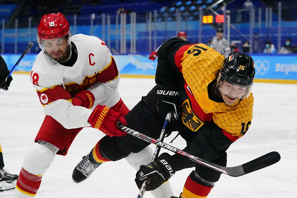 China’s Brandon Yip (left), or Ye Jinguang, and Germany’s Konrad Abeltshauser in a men’s ice hockey group game event at the Beijing Winter Olympic Games in the National Indoor Stadium. Photo: AP China’s Brandon Yip (left), or Ye Jinguang, and Germany’s Konrad Abeltshauser in a men’s ice hockey group game event at the Beijing Winter Olympic Games in the National Indoor Stadium. Photo: AP