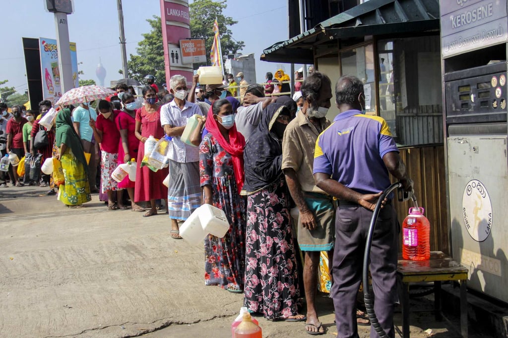 People stand in a queue to buy kerosene in Colombo in December 2021. Photo: AFP People stand in a queue to buy kerosene in Colombo in December 2021. Photo: AFP