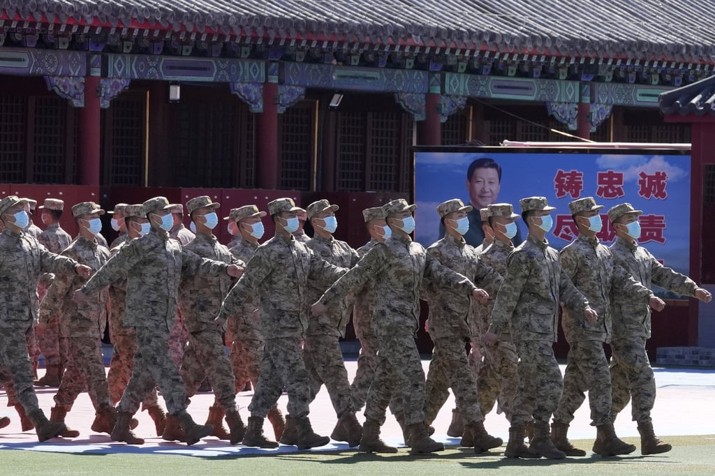 Members of a Chinese military honour guard marches past a poster depicting Chinese President Xi Jinping and slogans calling for loyalty and duty on Saturday in Beijing. Photo: AP