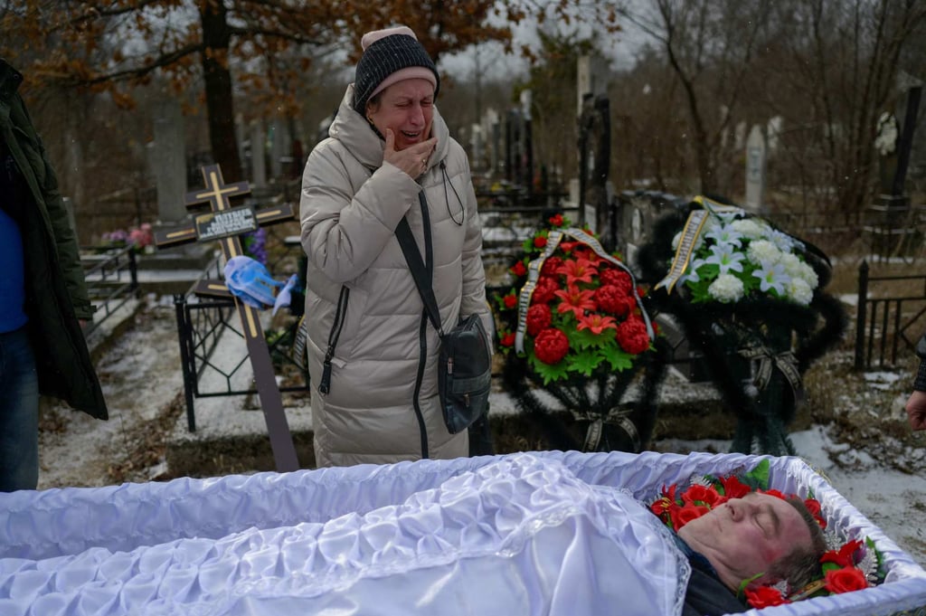 A woman grieves at the funeral of a man killed in shelling in Mykolaiv. Photo: AFP