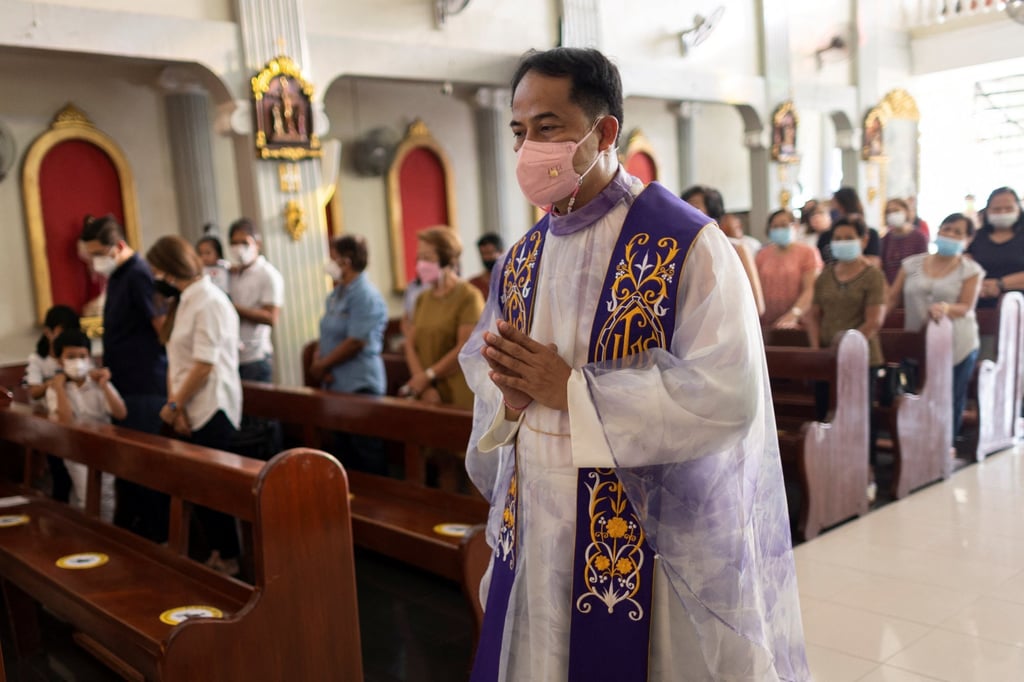Father Nap Baltazar, wearing a pink mask in support of Leni Robredo, at his parish in the Philippines’ Bulacan province. Photo: Reuters