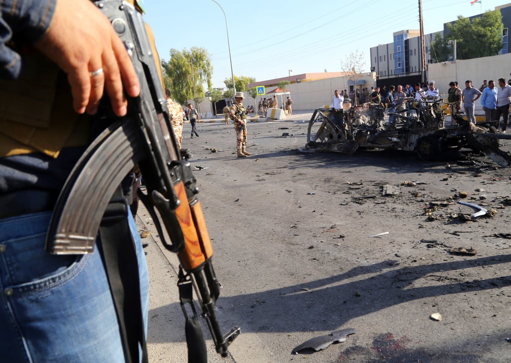 Kurdish security forces and citizens inspect the site of a car-bomb attack in front of the main security forces headquarters in Arbil, Iraq in September 2013. Photo: AP: Photo
