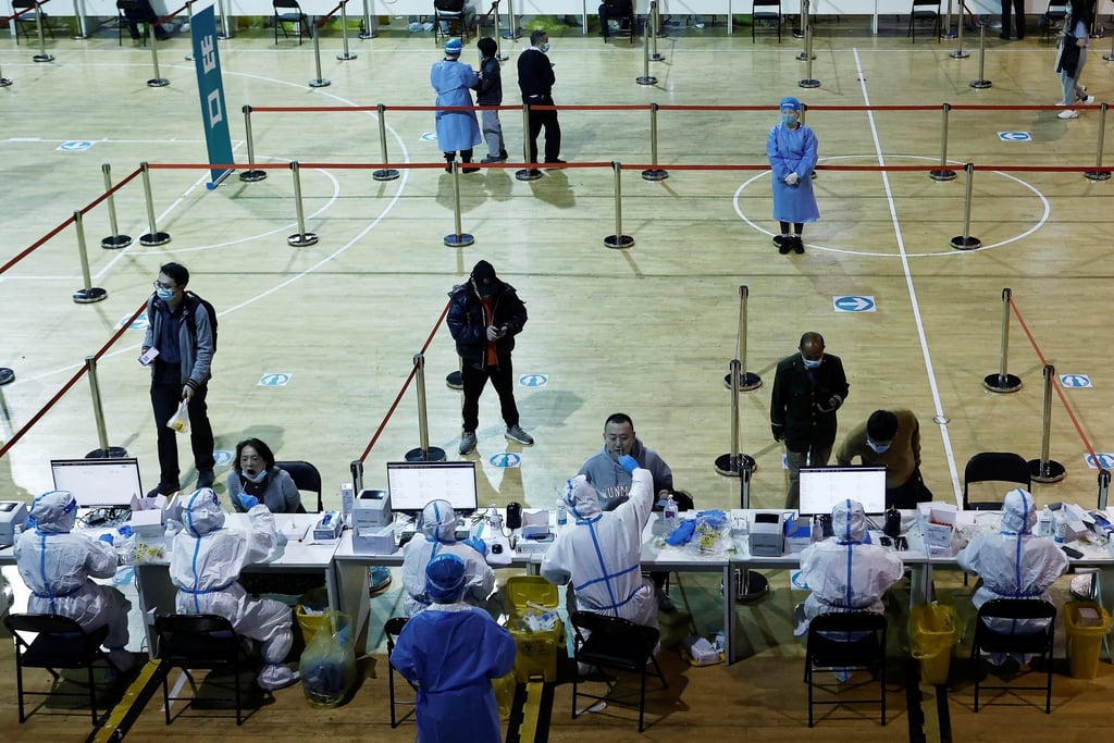 Medical workers in protective suits collect swabs from residents at a nucleic acid testing centre inside a Shanghai stadium on Monday. Photo: Reuters