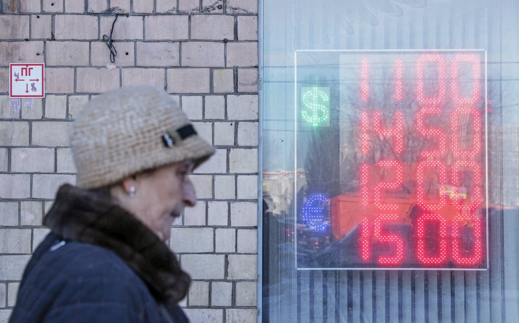 A woman walks past a board showing currency exchange rates of the Euro and the US dollar against the Russian rouble in Moscow, Russia, on March 11, 2022. Photo: Reuters