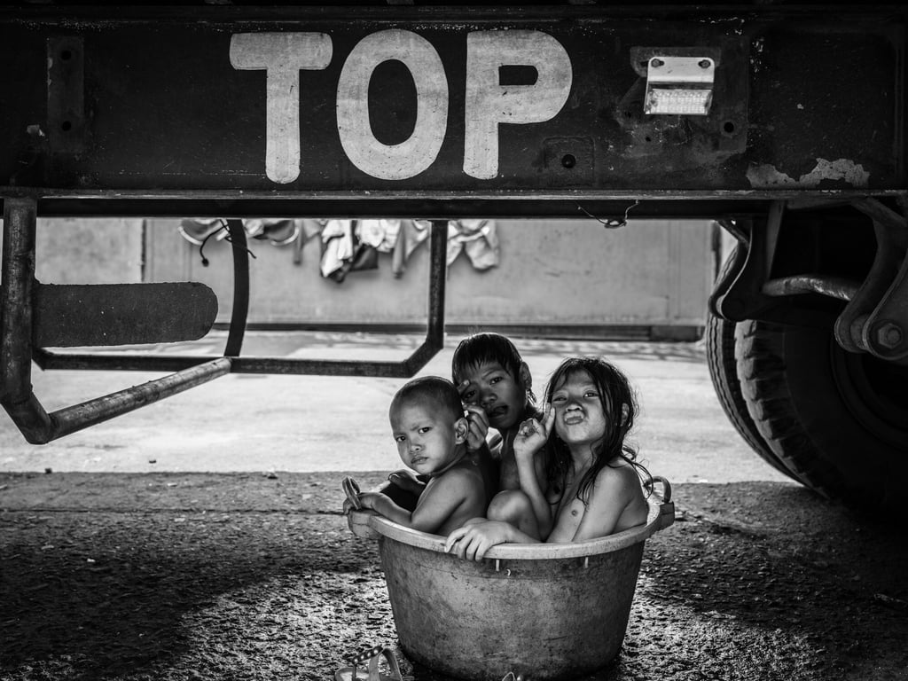Children bathe under a truck in Smokey Mountain, a former rubbish dump in the Philippines. Photo: Xyza Cruz Bacani / Christine Park Gallery Children bathe under a truck in Smokey Mountain, a former rubbish dump in the Philippines. Photo: Xyza Cruz Bacani / Christine Park Gallery