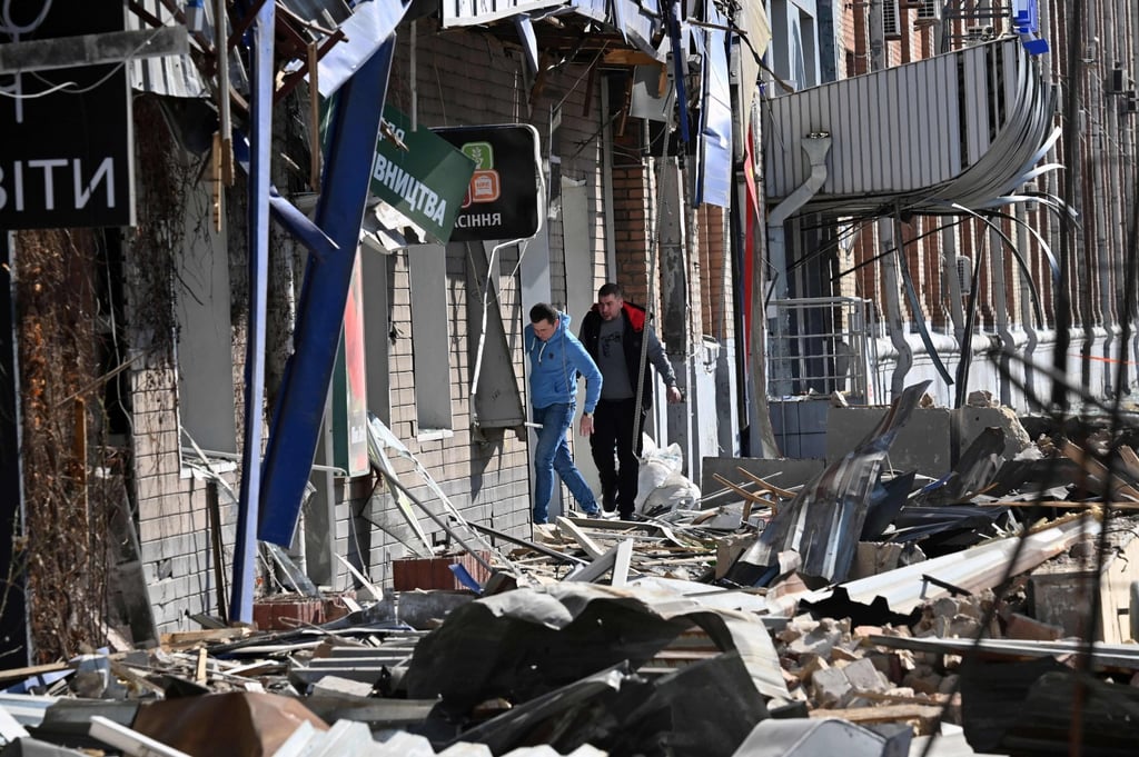 People walk by a building damaged by shelling amid Russian invasion of Ukraine in Kyiv. Photo: AFP People walk by a building damaged by shelling amid Russian invasion of Ukraine in Kyiv. Photo: AFP